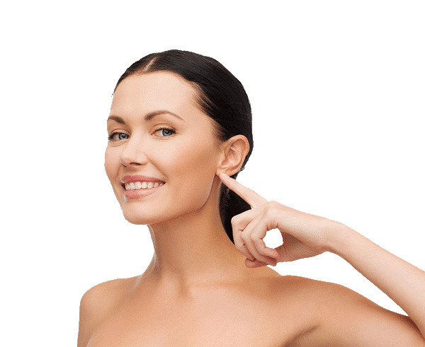 A woman pointing to her ear with a smile after otoplasty, isolated on a white background.