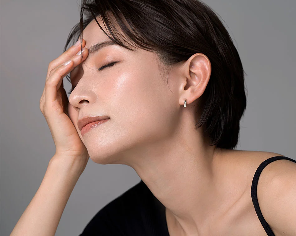 Close-up of a woman with short dark hair, eyes closed, and a serene expression, highlighting her smooth, radiant skin - Facials in Grand Rapids, MI